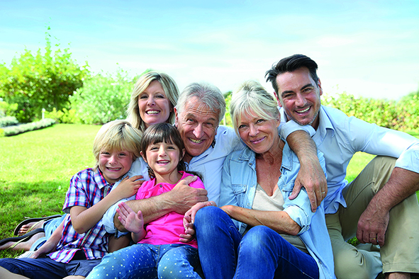 Gruppenfoto einer fröhlichen Familie bestehend aus Eltern, Großeltern und zwei Kindern